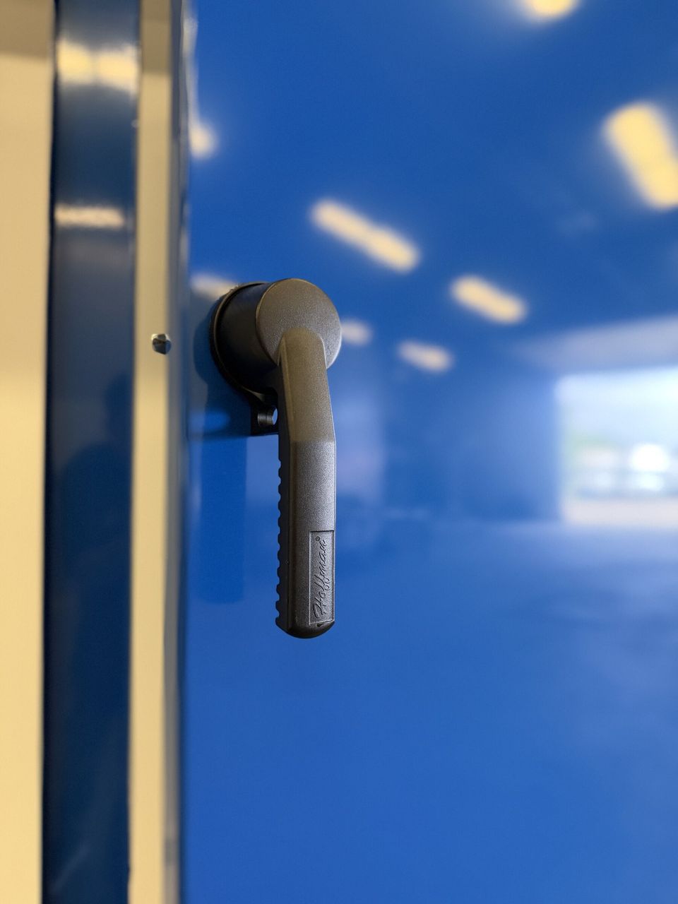 Close-up of a blue powder-coated cabinet door and handle
