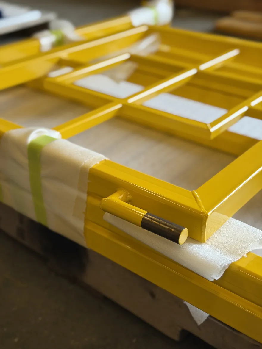 Yellow powder-coated steel frames wrapped for shipping